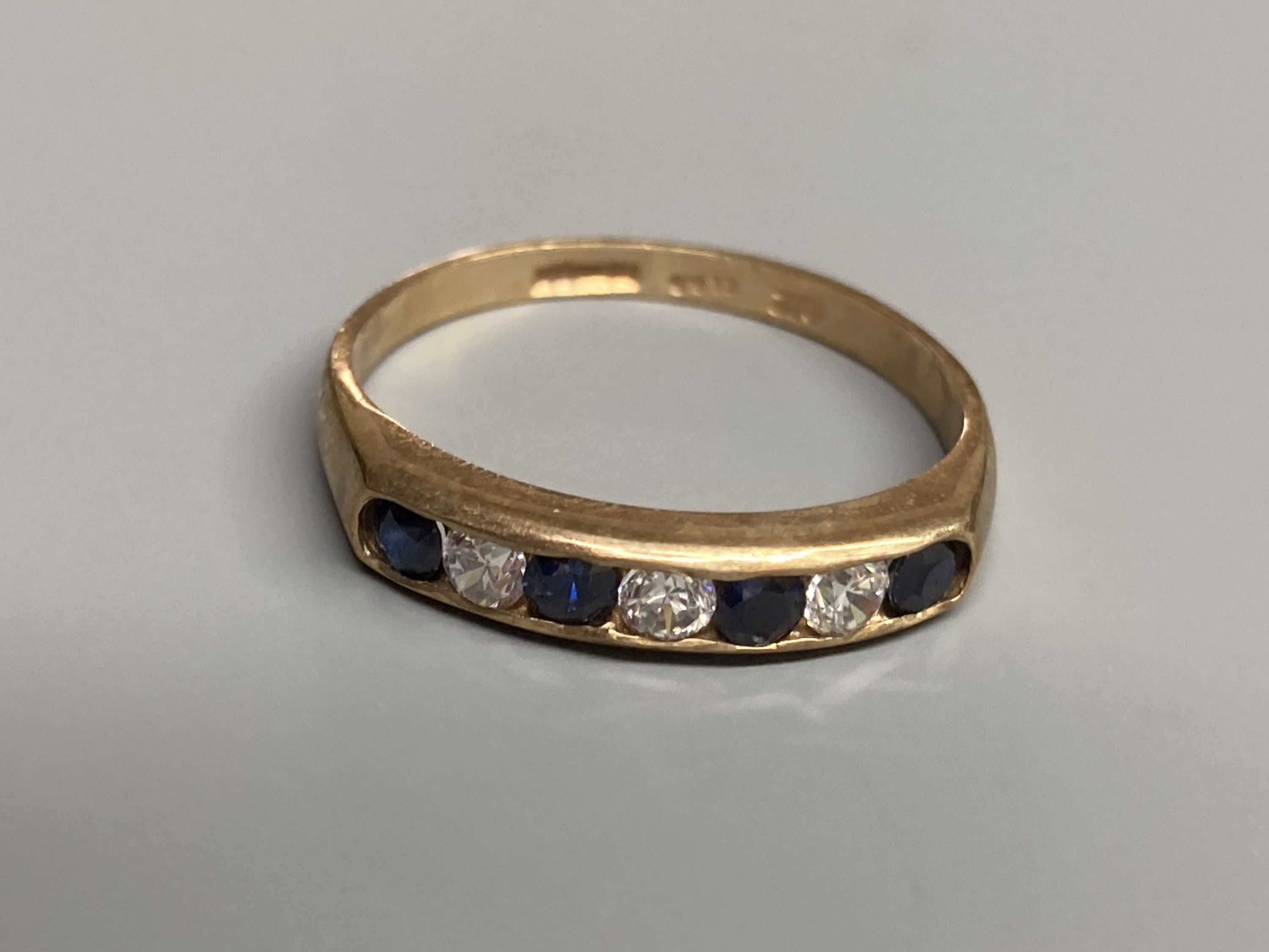 A modern 9ct gold, ruby and diamond set half hoop ring and a similar amethyst ring and two other 9ct gold gem set rings